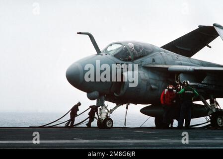 Des équipages de plate-forme de vol à bord du porte-avions à propulsion nucléaire USS DWIGHT D. EISENHOWER (CVN-69) à côté d'un Intrus A-6E de l'escadron d'attaque 34 (va-34). Pays : inconnu Banque D'Images