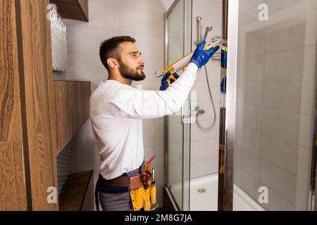 Plombier installation d'une cabine de douche dans la salle de bains Banque D'Images