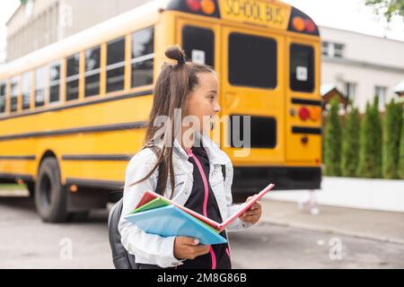 Belle petite fille avec sac à dos marche prêt à l'école, automne à l'extérieur, concept d'éducation Banque D'Images