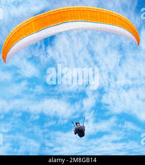 En montant dans le ciel. un homme parapente un jour ensoleillé. Banque D'Images