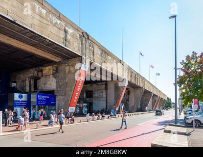 Les touristes seniors attendent une visite guidée du port en face de l'ancienne base sous-marine construite par l'armée allemande pendant la Seconde Guerre mondiale à Saint-Nazaire, en France Banque D'Images
