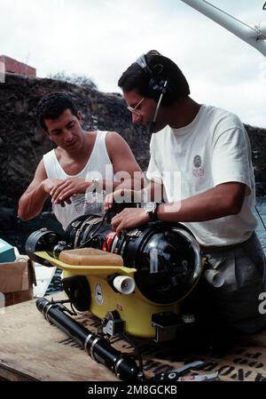 L'ingénieur Andy Bown, à droite, explique les fonctions d'un véhicule télécommandé au guide naturaliste Juan Carolos Naranjo. Les deux hommes participent au projet Jason, un effort conjoint de la Fondation Jason et des États-Unis La Marine a été conçue pour susciter de l'enthousiasme pour les domaines des sciences et de la technologie chez les élèves du primaire et du secondaire. Le projet est diffusé par satellite à des étudiants en Amérique du Nord et au Canada. Pays: Îles Galapagos Banque D'Images