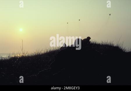 Les membres de la Division Marine 2nd prennent position sur une dune de sable après avoir fait un assaut amphibie sur Onslow Beach pendant l'exercice OCEAN VENTURE '92, trois hélicoptères CH-53E Super Stallion survolant. Objet opération/série: OCEAN VENTUE '92 pays: Océan Atlantique (AOC) Banque D'Images