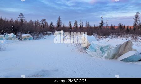 Vallée de la rivière Berkakit dans le sud de Yakutia avec des blocs de glace turquoise superposée. Paysage de soirée d'hiver. Banque D'Images