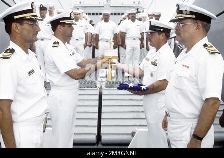 Les membres de l'équipage sont en formation alors que le MCPO Charles Cartwright présente l'urne contenant les restes du CDR Harold Schwartz au CAPT Robert James, commandant du navire-citerne USS RACINE (LST-1191), lors de l'enterrement à bord du navire. Schwartz a été médecin affecté au bataillon de parachutistes, 1st Division Marine, et a participé à des opérations de combat sur Guadalcanal, les îles Gilbert, les îles Marshall et Okinawa. L'enterrement en mer a lieu à Iron Bottom Sound au large de la côte de Guadalcanal. Pays : Océan Pacifique (POC) Banque D'Images