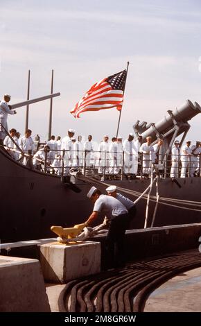 Les membres de l'équipage se tiennent près des canons de missiles surface à surface du RGM-8A Harpoon sur la poupe du croiseur de missiles guidé USS SHILOH (CG-67), tandis qu'ils regardent les marins fixer une ligne d'amarrage à l'embarcadère après l'arrivée de leur navire à son nouveau port d'attache. Base: Naval Air Station, San Diego État: Californie (CA) pays: Etats-Unis d'Amérique (USA) Banque D'Images