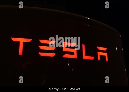 20 octobre 2022 Astana, Kazakhstan : logo Tesla rouge brillant sur fond sombre gros plan Banque D'Images