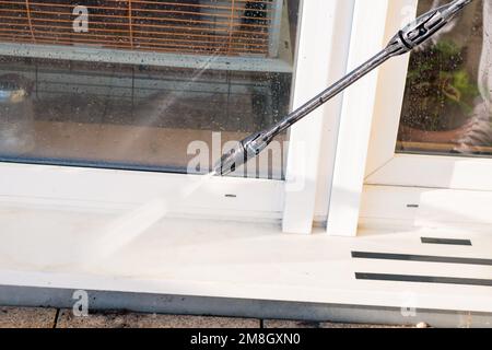 homme avec la terrasse de nettoyage de tube avec la pression de l'eau de la saleté Banque D'Images