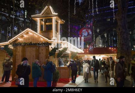 People Walking Round the Market stalles dans le marché de Noël à Leicester Square, Londres Royaume-Uni Banque D'Images
