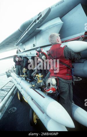 Les militaires de l'aviation montent un missile air-air AIM-7 Sparrow sur un pylône d'aile d'un avion Fighter Squadron 32 (VF-32) F-14A Tomcat sur le porte-avions USS JOHN F. KENNEDY (CV-67). Pays: Mer Adriatique Banque D'Images