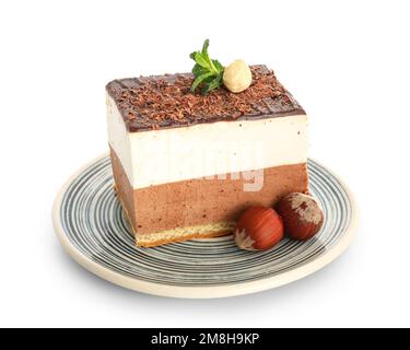 Assiette avec gâteau au lait aux oiseaux, noisettes et feuilles de menthe sur fond blanc Banque D'Images