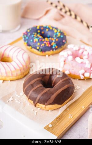 Embarquez avec différents beignets délicieux sur une table blanche Banque D'Images