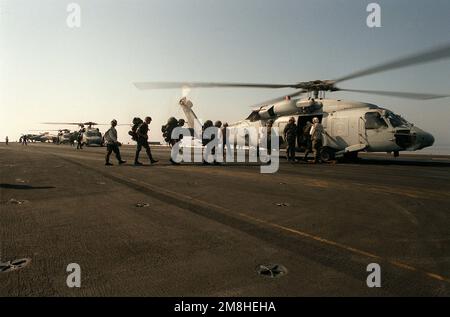 Des membres de la Force opérationnelle aérienne terrestre marine à but spécial (SPMAGTF) embarquent à bord d'un hélicoptère de l'escadron anti-sous-marin 3 (HS-3) SH-60F Sea Hawk sur le pont de vol du porte-avions à propulsion nucléaire USS THEODORE ROOSEVELT (CVN-71). Les Marines vont participer à un exercice de formation en Italie. Le ROOSEVELT opère dans l'Adriatique à l'appui de l'opération Deny Flight. Objet opération/série: DENY FLIGHT pays: Mer Adriatique Banque D'Images