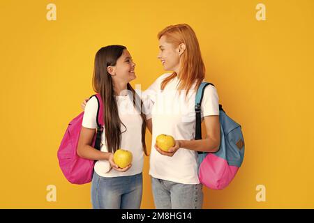 Concept d'école, d'apprentissage et d'éducation. Mère et fille écolières avec sac à dos d'école et pomme prêt à apprendre Banque D'Images