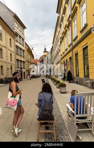 Personnes assises sur des marches et des bancs à Graz, en Styrie, en Autriche et dans les environs Banque D'Images