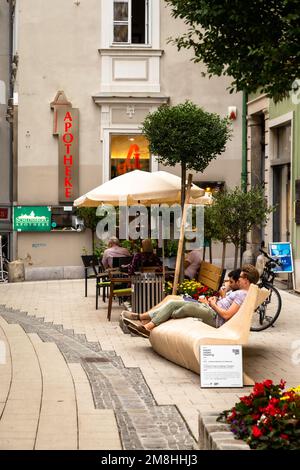 Personnes assises sur des marches et des bancs à Graz, en Styrie, en Autriche et dans les environs Banque D'Images