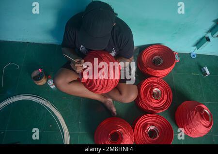 Malang, Indonésie. 13th janvier 2023. Les artisans font des lanternes rouges en préparation de la fête du nouvel an chinois. Les ventes de ces lanternes ont augmenté depuis deux mois, avec une vente moyenne de 6 000 unités. En plus d'être vendus dans des régions d'Indonésie, ces lanternes sont également exportées vers l'Italie, autour de 3 000 unités. (Photo de Moch Farabi Wardana/Pacific Press) crédit: Pacific Press Media production Corp./Alay Live News Banque D'Images