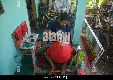 Malang, Indonésie. 13th janvier 2023. Les artisans font des lanternes rouges en préparation de la fête du nouvel an chinois. Les ventes de ces lanternes ont augmenté depuis deux mois, avec une vente moyenne de 6 000 unités. En plus d'être vendus dans des régions d'Indonésie, ces lanternes sont également exportées vers l'Italie, autour de 3 000 unités. (Photo de Moch Farabi Wardana/Pacific Press) crédit: Pacific Press Media production Corp./Alay Live News Banque D'Images