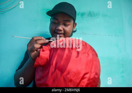 Malang, Indonésie. 13th janvier 2023. Les artisans font des lanternes rouges en préparation de la fête du nouvel an chinois. Les ventes de ces lanternes ont augmenté depuis deux mois, avec une vente moyenne de 6 000 unités. En plus d'être vendus dans des régions d'Indonésie, ces lanternes sont également exportées vers l'Italie, autour de 3 000 unités. (Photo de Moch Farabi Wardana/Pacific Press) crédit: Pacific Press Media production Corp./Alay Live News Banque D'Images