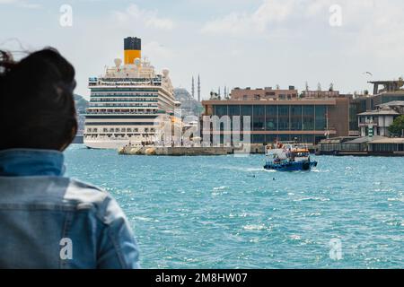 Galataport Istanbul Turquie - bateau de croisière de la Costa Venezia amarré à Galataport vu du bateau de croisière local alors que de petits bateaux et dauphins passent Banque D'Images