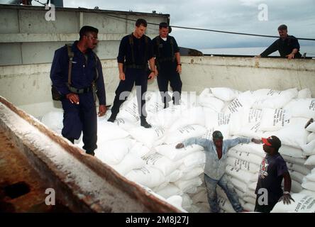 Les membres d'équipage du navire marchand À destination haïtienne, LE NOIR EAGLE, déplacent la cargaison de farine de sorte que la partie d'embarquement de la frégate d'entraînement USS AINSWORTH (FFT-1090) puisse vérifier la contrebande lors d'une inspection du navire dans le cadre de l'opération support Democracy, L'embargo des Nations Unies sur les armes et le carburant en Haïti. Il s'agit de l'inspection de 100th depuis la mise en place des sanctions sur 18 octobre. Sujet opération/série: SOUTENIR LA DÉMOCRATIE pays: Mer des Caraïbes Banque D'Images