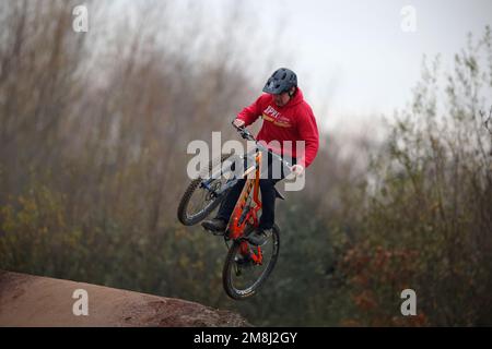 Les coureurs de VTT en action sur une piste de BMX et de pompe près de Fleet dans le Hampshire. Banque D'Images