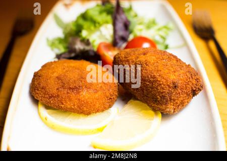 Croquettes espagnoles. La croquette est une portion de pâte faite à partir d'une sauce dense comme le bechamel et un mincemeat de divers ingrédients ou légumes. Banque D'Images