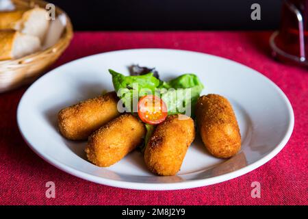 Croquettes espagnoles. La croquette est une portion de pâte faite à partir d'une sauce dense comme le bechamel et un mincemeat de divers ingrédients ou légumes. Banque D'Images