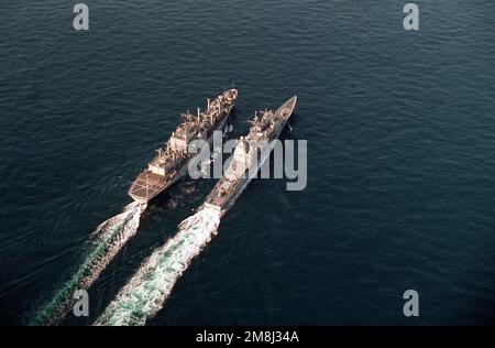 Vue aérienne de l'avant-port du croiseur de missiles guidé de classe Ticonderoga USS HUE CITY (CG-66) et du navire de soutien de combat de classe Mars USS SYLVANIA (AFS-2), en cours de reconstitution en mer au large de la zone d'exploitation des capes de Virginie. Pays: Océan Atlantique (AOC) Banque D'Images