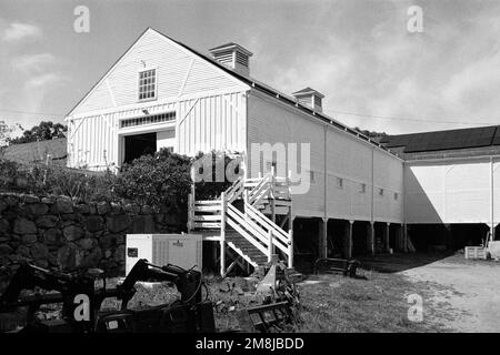 L'équipement agricole se trouve au sol sous une grande grange blanche contenant le magasin agricole des fermes communautaires Codman. Lincoln, Massachusetts. L'image Banque D'Images