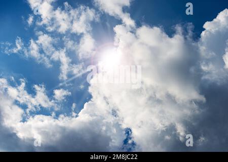 Beau ciel bleu avec des cumulus blancs et des rayons de soleil (rayons de soleil).Photographie en contre-jour. Banque D'Images