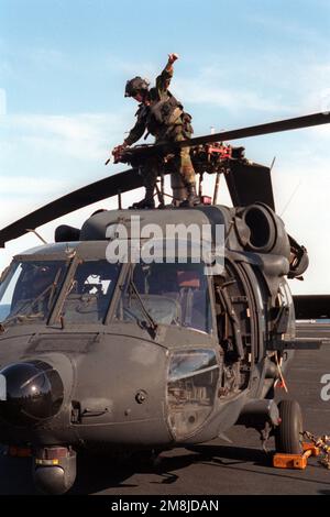 Membres d'un crewmembers des États-Unis Hélicoptère de commandement et de contrôle MH-60 Black Hawk (Blackhawk) de l'Armée de terre du 2nd Bataillon, 160th Special Operations Aviation Regiment à fort Campbell, Ky. Repliez manuellement les pales du rotor pour stationner l'avion sur le pont de vol du porte-avions à propulsion nucléaire USS GEORGE WASHINGTON (CVN-73) pendant l'exercice de la flotte 2-94. Objet opération/série : EXERCICE DE FLOTTE 2-94 pays : océan Atlantique (AOC) Banque D'Images