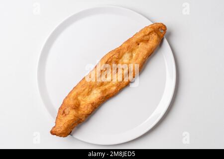 Sur le bâton de pâte frite, faire l'appoint dans un plat blanc Mekitsa ou mekika traditionnel serbe bulgare et un plat macedoinan fait de pâte à pétrir Banque D'Images