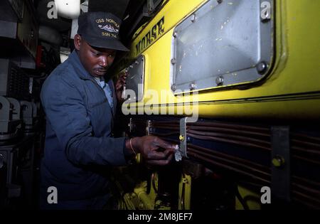 Machiniste Mate First Class (MM1) Prince Stokley nettoie le moteur diesel auxiliaire à bord du sous-marin d'attaque nucléaire USS NORFOLK (SSN-714). Pays: Chesapeake Bay Banque D'Images