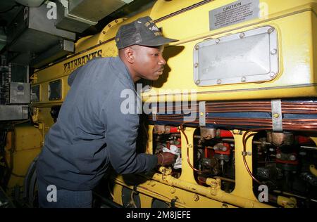 Machiniste Mate First Class (MM1) Prince Stokley nettoie le moteur diesel auxiliaire à bord du sous-marin d'attaque nucléaire USS NORFOLK (SSN-714). Pays: Chesapeake Bay Banque D'Images