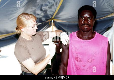 Hôpital Corpsman troisième classe (HM3) Darlene Godino, de l'unité de médecine de protection de l'environnement de la Marine #2 (NEPMU-2), Norfolk, va, donne des injections de diphtérie aux Haïtiens du Camp 4 dans le cadre de leur traitement médical. Objet opération/série: BASE DE SIGNAL MARITIME: Guantanamo Bay pays: Cuba (CUB) Banque D'Images