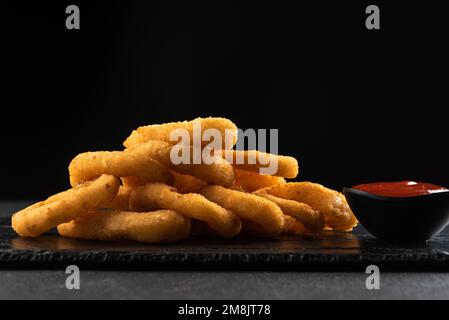 Croustillant d'oignon frit fait maison avec une sauce tomate Banque D'Images