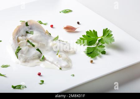 Poisson de hareng mariné à la sauce mayonnaise aux herbes - vue rapprochée Banque D'Images