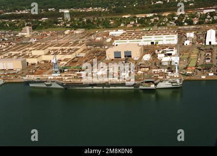 Une vue latérale du port aérien du porte-avions À propulsion nucléaire JOHN C. STENNIS (CVN-74) a été attachée à la jetée d'aménagement du Newport News Shipbuilding et de Drydock Corporation sur la rivière James. Le STENNIS a été lancé en novembre dernier et ne sera mis en service qu'en novembre 1995. La gamme de matériaux de construction sur le pont de vol sert en fait à camoufler le navire dans le rivage. Base: Newport News État: Virginie (va) pays: Etats-Unis d'Amérique (USA) Banque D'Images