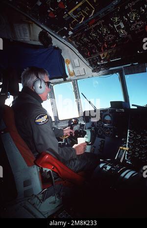 Le vice-amiral Robert J. Spane, commandant de la Naval Air Force, US Pacific Fleet, prend un virage aux commandes d'un avion C-130 Hercules de l'Escadron de développement de l'Antarctique six (VXE-6) en route vers la station McMurdo lors d'une course de transport. Sujet opération/série : opération Deep Freeze pays : Antarctique (ATA) Banque D'Images