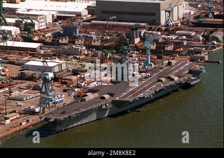Une vue aérienne de l'avant-port du porte-avions à propulsion nucléaire USS ENTERPRISE (CVN-65) a été arrimée à Newport News Shipbuilding et à Drydock Corporation sur la rivière James pour une remise en état après coup de main. Au-dessus et derrière le Big E, on peut voir le nouveau navire de transport de véhicule du Commandement militaire Seallift USNS GILLILAND (T-AKR-298) en cours de conversion en quai sec #11. Base: Newport News État: Virginie (va) pays: Etats-Unis d'Amérique (USA) Banque D'Images