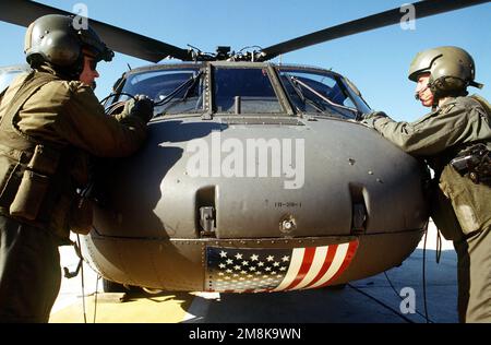 Les pilotes d'un hélicoptère UH-60 Black Hawk (Blackhawk) préparent leur helo pour une mission à l'appui de l'opération. Deux hélicoptères effectuent des voyages quotidiens entre la base aérienne de Diyarbakir, en Turquie, et Zahku transportant du personnel et des fournitures. Cette opération est une mission de sécurité visant à faire respecter la zone d'exclusion aérienne des Nations Unies au nord du parallèle à 36 degrés de l'incursion aérienne et terrestre iraquienne. Une coalition de quatre nations composée des États-Unis, de la Turquie, de la Grande-Bretagne et de la France a activement protégé et fourni des réfugiés kurdes depuis la tempête du désert en 1991 (date exacte inconnue). Sujet opération/série: FOURNIR LE CONFORT base: Zakh Banque D'Images