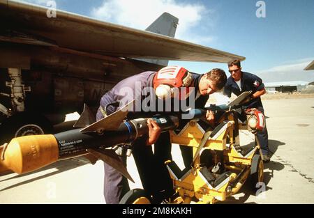 LES munitions de l'aviation DE LA US Navy soulèvent un missile SIDEWINDER AIM-9 d'un berceau de transport. Les munitions chargeront le missile sur le F/A-18 Hornet du Strike Fighter Squadron 113 (VFA-113), de la base aérienne navale de Lemoore (Californie), pour une autre mission au cours de l'exercice annuel de défense aérienne. Objet opération/série: ROVING SANDS '95 base: Roswell État: Nouveau Mexique (NM) pays: États-Unis d'Amérique (USA) Banque D'Images