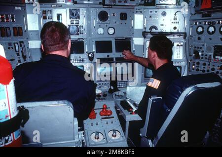 Machiniste Mate First Class (MM1) Brett Jábia montres LT. CMDR. David Olivier, commandant de la NR-1, le seul engin de recherche en immersion profonde à propulsion nucléaire de la Marine, ajuste certains instruments en naviguant au large de Key Largo, en Floride. Pays: Mer des Caraïbes Banque D'Images