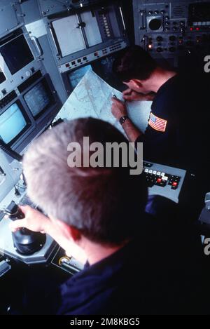 Machiniste Mate First Class (MM1) Brett Jebia montres LT. CMDR. David Olivier, commandant de la NR-1, le seul engin de recherche en immersion profonde à propulsion nucléaire de la Marine, vérifie ses cartes à bord de l'submersible au large de Key Largo, en Floride. Pays: Mer des Caraïbes Banque D'Images