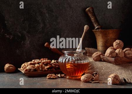 Miel et noix sur une table de cuisine ancienne. Banque D'Images