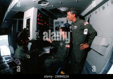 LE Sergent technique DE LA Force aérienne AMÉRICAINE Jennifer Rainey, L'AVIATEUR PRINCIPAL Paul Havell et le SERGENT-MAÎTRE Vincent Minnillo (debout), tous les chargés de charge du 17th Airlift Squadron, base aérienne de Charleston, en Caroline du Sud, apprécient les systèmes automatisés à bord d'un C-17 Globemaster III. D'AIRMAN Magazine, octobre 1995, article « Redemption ». Base: Charleston Air Force base État: Caroline du Sud (SC) pays: Etats-Unis d'Amérique (USA) Banque D'Images