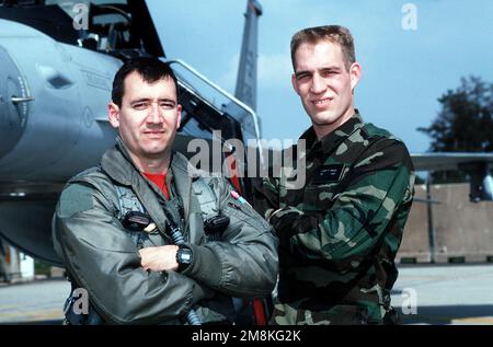 Le capitaine de l'USAF (CPT) Tom Smith (à gauche), un pilote d'avion F-16 Falcon affecté au 22nd Escadron de chasse, à la base aérienne de Spangdahlem (Allemagne) et JASON Fowler, un aviateur PRINCIPAL de l'USAF (SRA), un spécialiste des systèmes d'armement de l'aéronef, le 22nd Escadron de chasse, posent pour une photographie sur la ligne de vol à Spangdahlem AB (Allemagne). CPT Smith et SRA Fowler ont tous deux été forcés d'éjecter de l'avion F-16 Falcon dans lequel ils volaient lorsque le moteur de l'avion était en panne. D'après L'article du NUMÉRO d'août 1995 d'AIRMAN Magazine, « Friday the 13th: The Horror continue-Jason Jettissioned ». Base: Lackland Air Force base État: Texas Banque D'Images