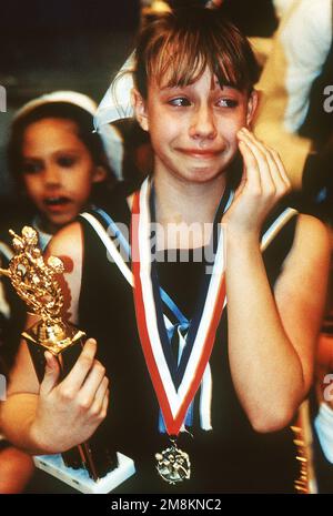 Photographe militaire de l'année gagnante 1996 titre: Première place Catégorie: Sports place: Mention honorable brève Description: Une jeune gymnaste tient son trophée d'une main et essuie ses larmes de l'autre main. Date exacte prise de vue inconnue. Pays : inconnu Banque D'Images