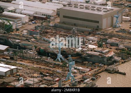 Vue latérale du port aérien du porte-avions à propulsion nucléaire USS Dwight D. Eisenhower (CVN-69) dans le quai no 11 de la Newport News Shipbuilding and Drydock Corporation en cours de révision. Le labyrinthe de l'équipement et de l'équipement de construction sur la plate-forme de vol camouflent efficacement le navire dans la zone latérale de la jetée. Base: James River État: Virginie (va) pays: Etats-Unis d'Amérique (USA) Banque D'Images